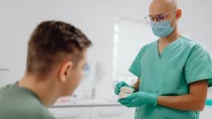 Dentist reviewing dental malpractice insurance coverage with patient in clinic