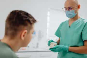 Dentist reviewing dental malpractice insurance coverage with patient in clinic